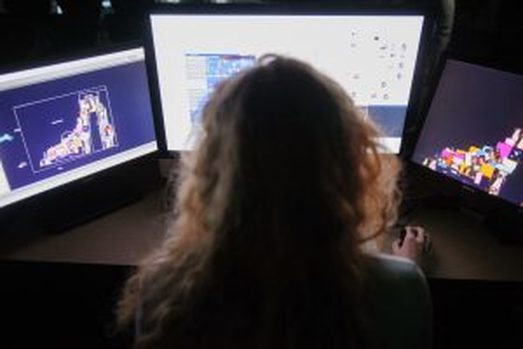 Picture of Laura Rubisch working at multiple computer screens